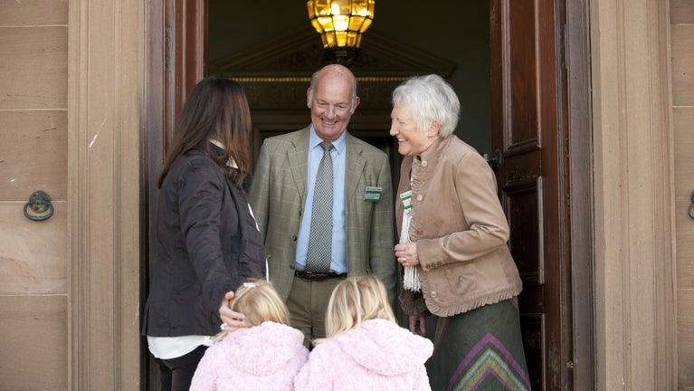 Volunteer guides warmly assisting visitors at Berrington Hall, Herefordshire - a snapshot of shared smiles and helpful encounters.